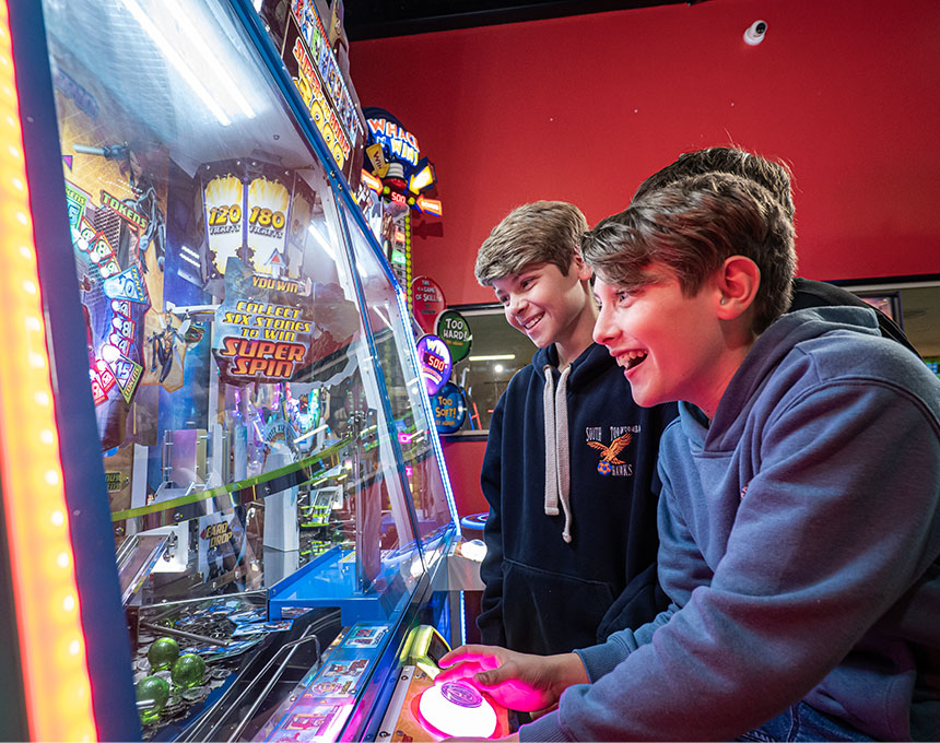 Boys playing arcade game at Sunset Superbowl