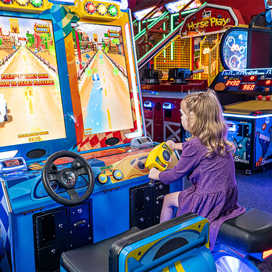 Girl playing arcade games at Sunset Superbowl