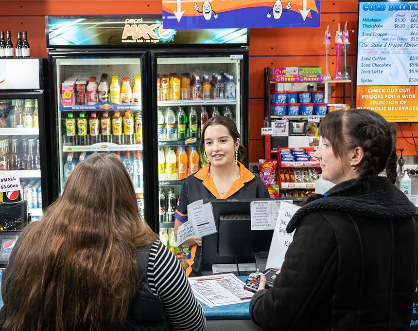 Team member at Sunset Superbowl helping customers purchase lunch